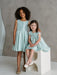 Teter Warm Tiffany Blue Sleeveless Party Dress modeled by two young girls in a studio setting.