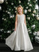 Teter Warm Tori off-white lace communion dress worn by girl standing in front of decorated Christmas tree.