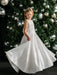 Teter Warm Tori off-white lace communion dress worn by a girl twirling in front of a Christmas tree.