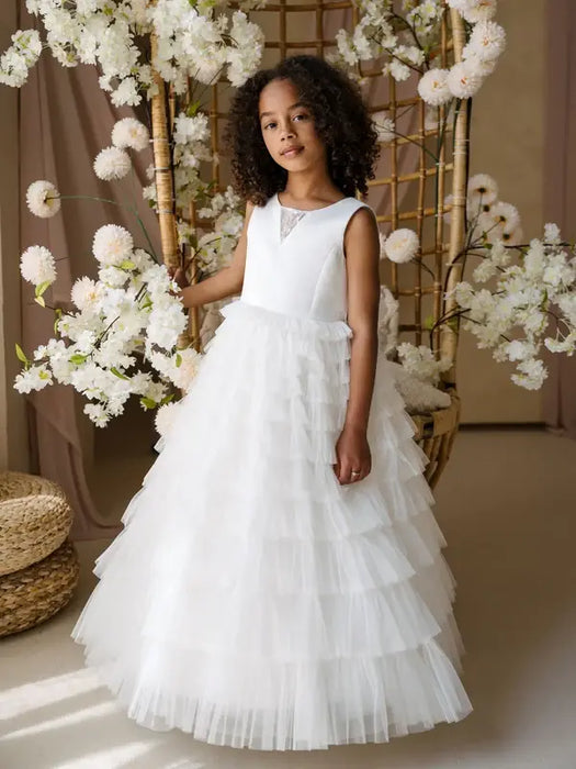 Teter Warm Winniw Off-White Communion Dress worn by a girl standing among white floral decor.