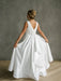 Teter Warm Yasmin off white communion dress shown on a girl from the back in a studio setting.