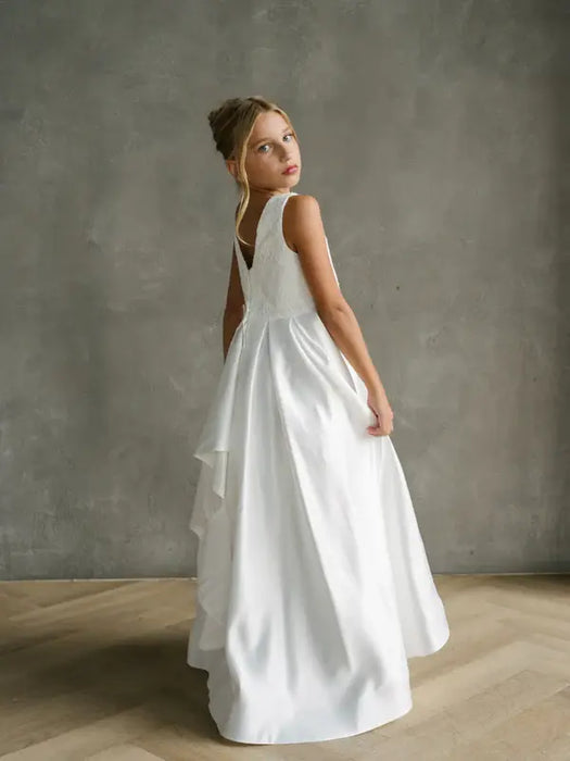 Teter Warm Yasmin off-white communion dress on a young girl standing in a studio setting.