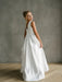 Teter Warm Yasmin off-white communion dress on a young girl standing in a studio setting.