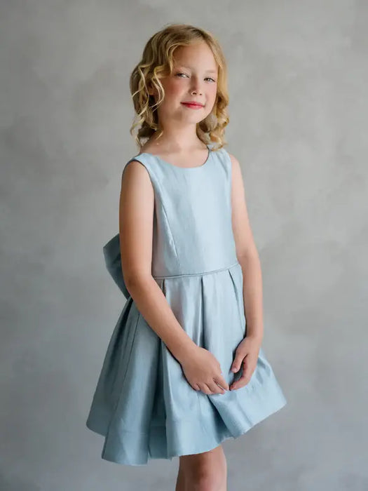 Teter Warm Zelda blue party dress shown on a young girl standing against a neutral background.