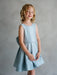 Teter Warm Zelda blue party dress shown on a young girl standing against a neutral background.
