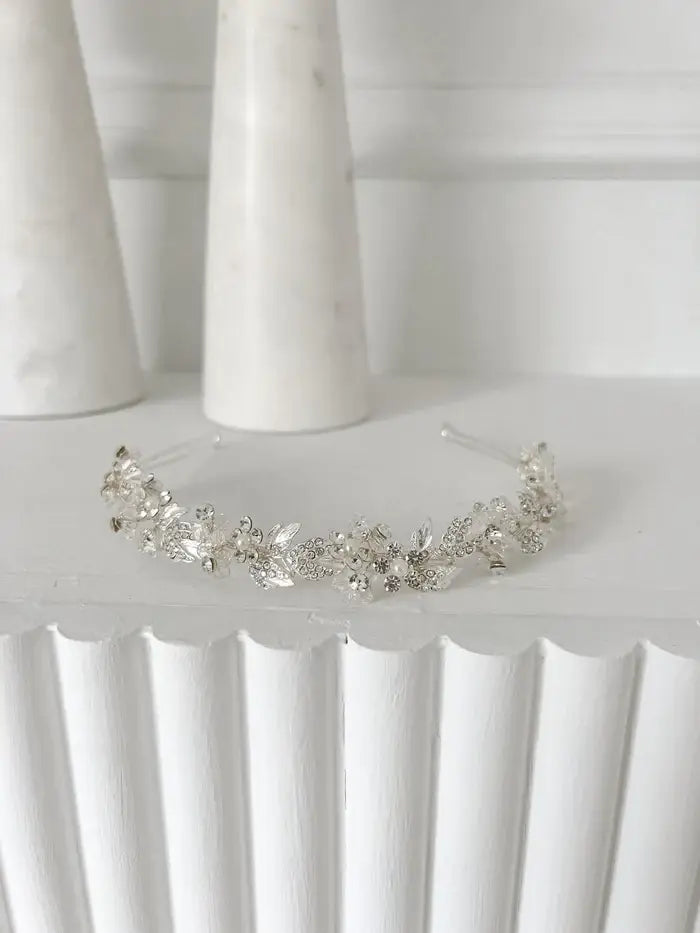 Lydia rhinestone and pearl headpiece displayed on a white fluted surface with a minimalist background.