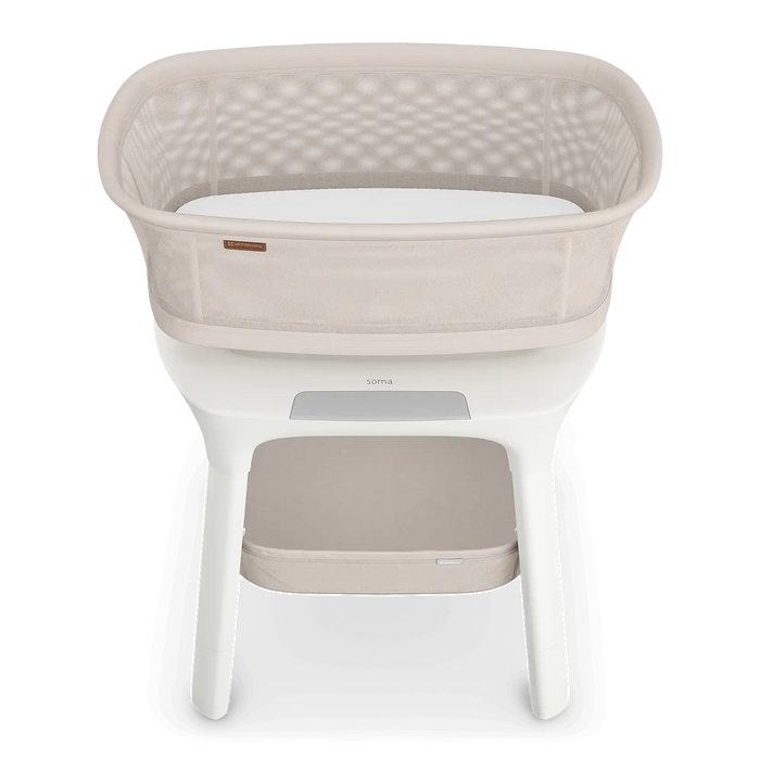 Modern beige baby bassinet with mesh sides and white storage shelf