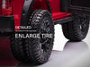 Voltz Toys F-450 lifted ride-on car showing close-up of large detailed rear tires on a white floor.