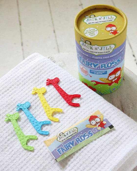 Jack N' Jill Fairy Floss dental floss 30 pack with colorful giraffe flossers on a white towel.