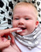 Wellbeing Island silicone finger brush used to clean a smiling baby's teeth at home