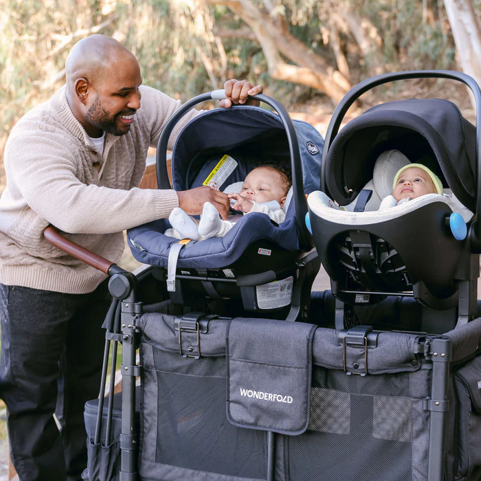 Wonderfold 360 L4 car seat adapter holding two infant car seats on stroller outdoors
