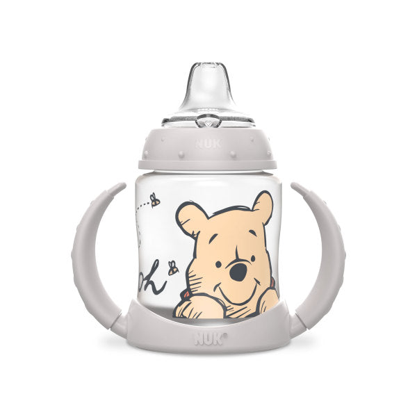 NUK baby sippy cup with Winnie the Pooh design and ergonomic handles shown on white background.